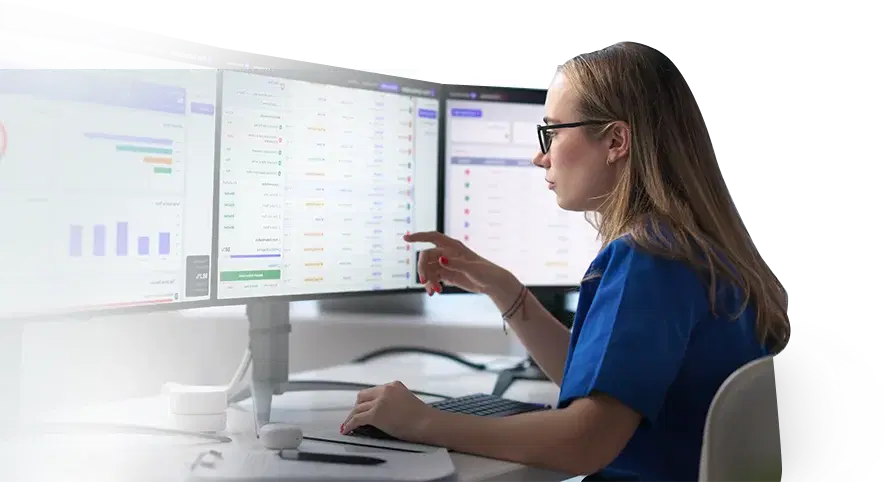 Revenue-cycle analyst reviewing claim findings across monitors